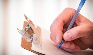 A picture of a man signing a piece of paper