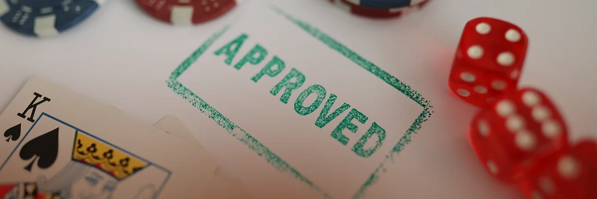 Casino chips, dice, and playing cards next to an 'Approved' stamp symbolizing verified geolocation for legal online betting