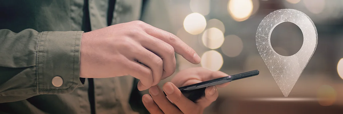 Person using a smartphone with a digital location icon overlay