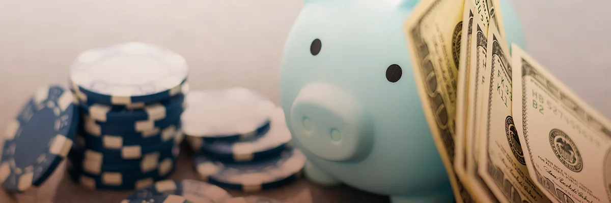 Piggy bank with cash and casino chips symbolizing depositing funds for online gambling